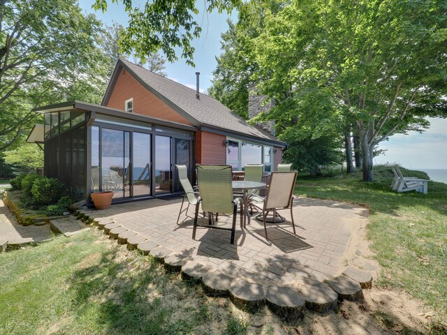 back of house featuring a yard, a patio, and a sunroom