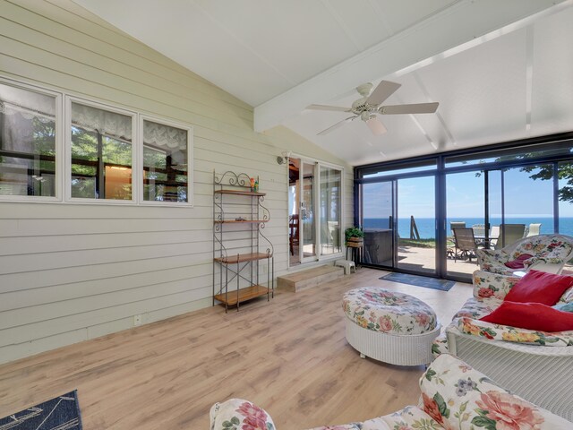 living room with lofted ceiling with beams, hardwood / wood-style flooring, a water view, and ceiling fan