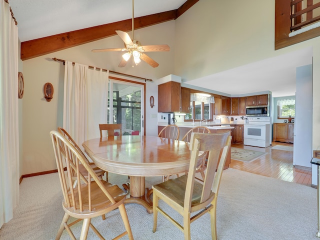 dining area featuring high vaulted ceiling, beamed ceiling, light carpet, sink, and ceiling fan