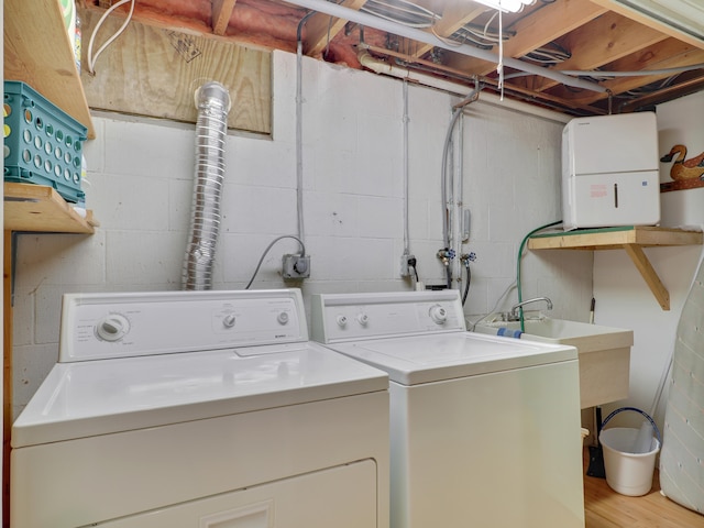 washroom with washing machine and dryer and light hardwood / wood-style floors