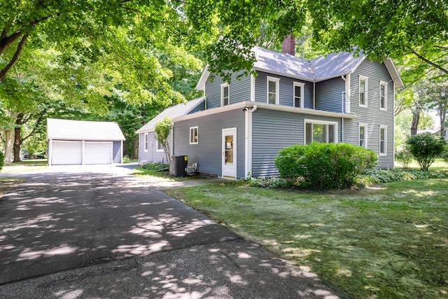 exterior space with a garage, an outbuilding, and a yard