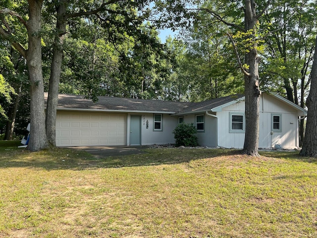 back of property featuring a garage and a lawn