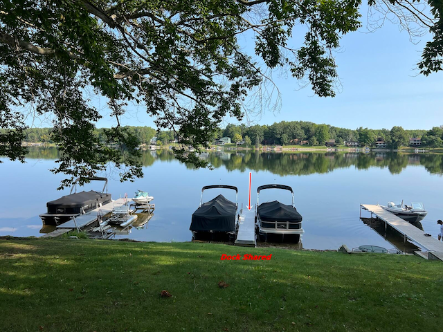 dock area with a water view and a yard