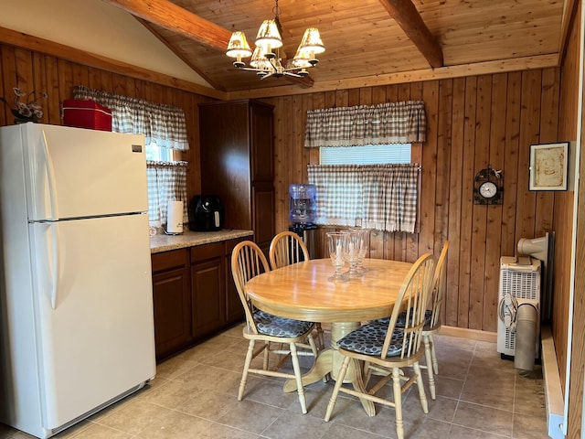 tiled dining area with lofted ceiling with beams, wooden walls, wood ceiling, and a chandelier