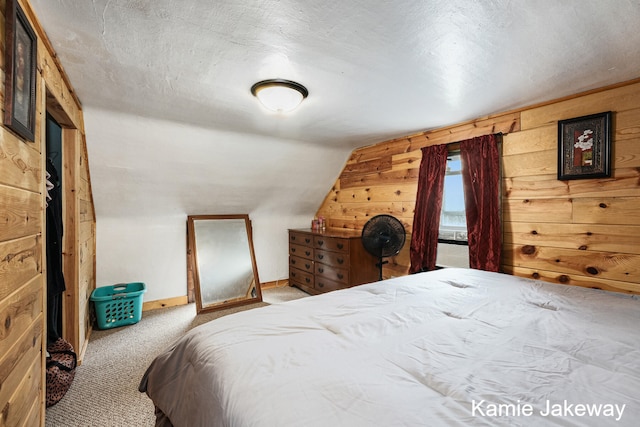 carpeted bedroom with a textured ceiling and wooden walls