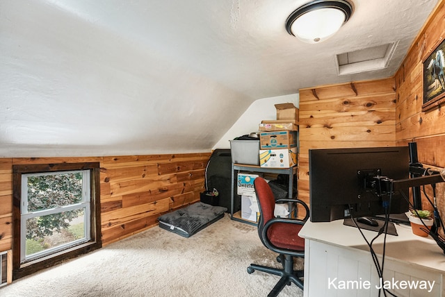 carpeted office space with wood walls and vaulted ceiling