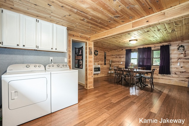 clothes washing area with washer and dryer, wooden ceiling, light hardwood / wood-style flooring, and wooden walls