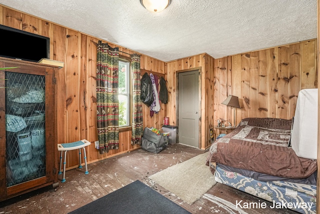 bedroom with wood walls and a textured ceiling