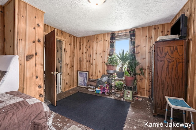 interior space featuring wood walls, hardwood / wood-style floors, and a textured ceiling