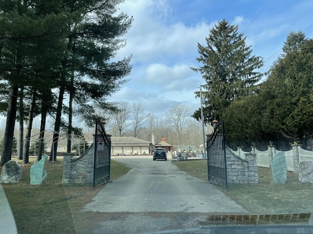 view of road with aphalt driveway, a gate, and a gated entry