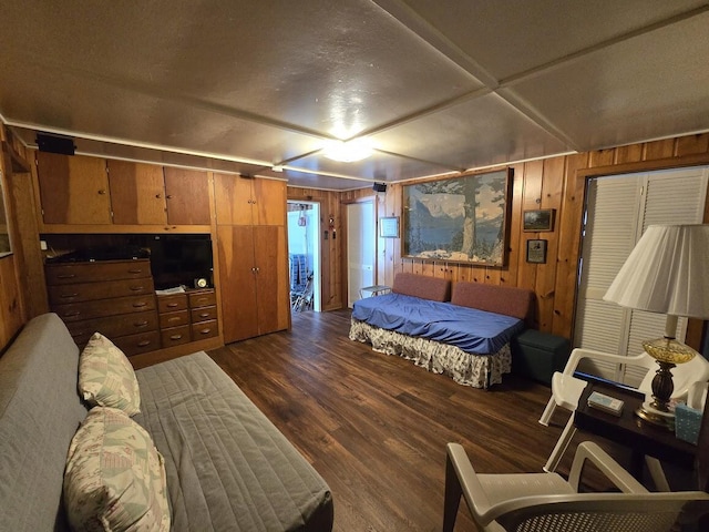 bedroom with dark hardwood / wood-style floors and wood walls