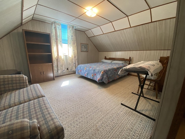 bedroom with vaulted ceiling, wood walls, and carpet flooring