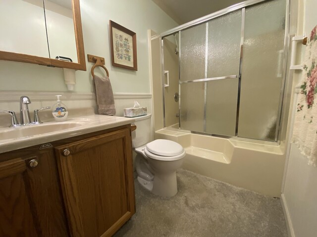 bathroom featuring toilet, shower / bath combination with glass door, and vanity