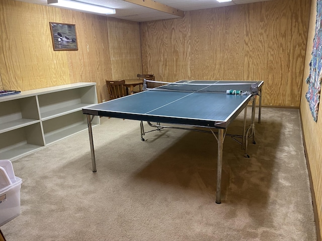 recreation room with carpet flooring and wood walls