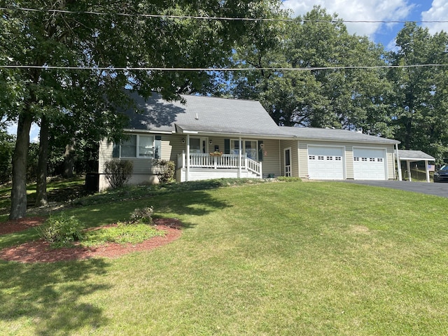 single story home with a porch, a front yard, driveway, and an attached garage