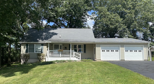 view of front of home with covered porch, aphalt driveway, a front yard, and a garage