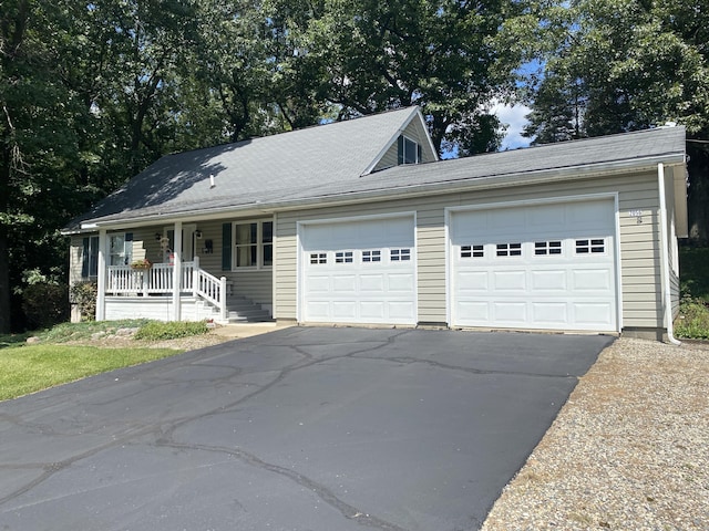 view of front facade with covered porch, driveway, and an attached garage