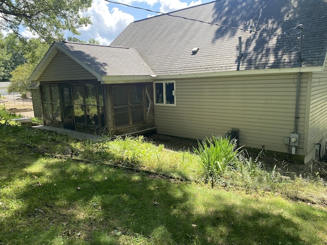 rear view of house with a yard and a sunroom