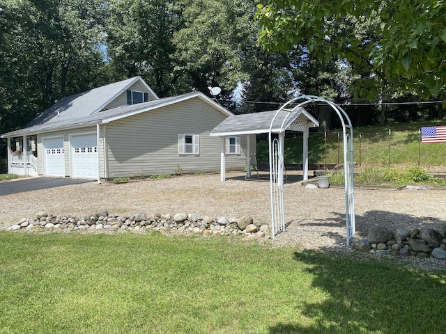 view of property exterior with aphalt driveway, a yard, and an attached garage