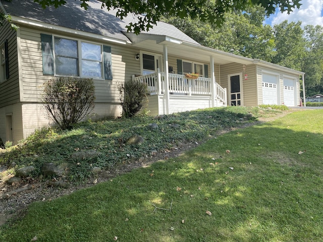 ranch-style home featuring an attached garage, a front lawn, a porch, and roof with shingles