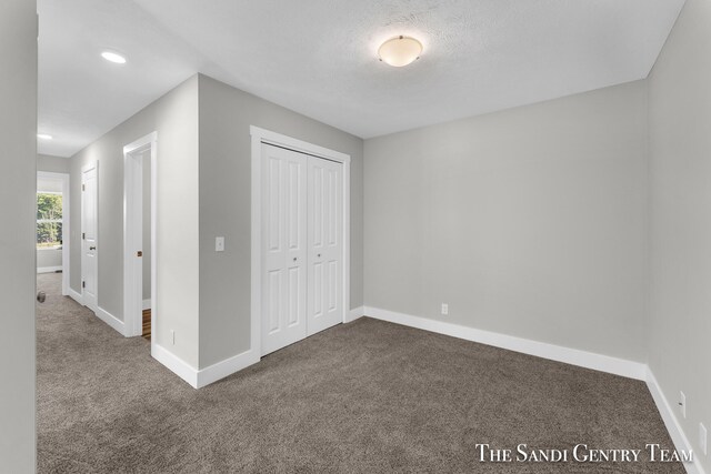 unfurnished bedroom with a closet and carpet floors