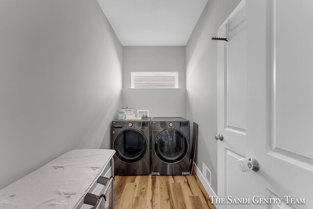 laundry room with light hardwood / wood-style flooring and separate washer and dryer