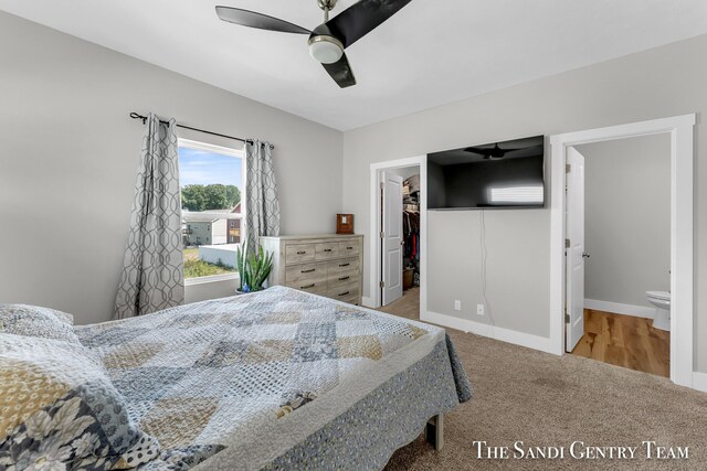 bedroom featuring ceiling fan, ensuite bathroom, a spacious closet, carpet flooring, and a closet