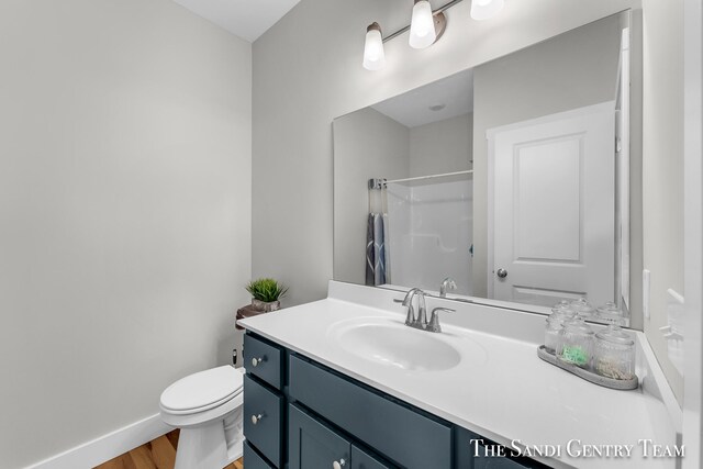 bathroom with vanity, toilet, and hardwood / wood-style floors