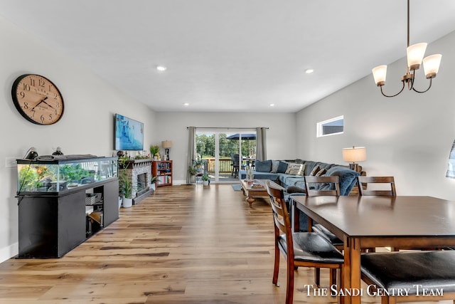 dining room with light hardwood / wood-style flooring and an inviting chandelier