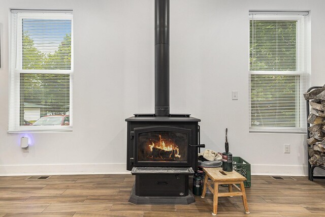 interior details featuring hardwood / wood-style floors and a wood stove