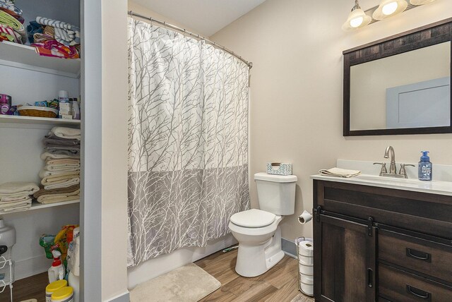 bathroom with hardwood / wood-style flooring, vanity, and toilet