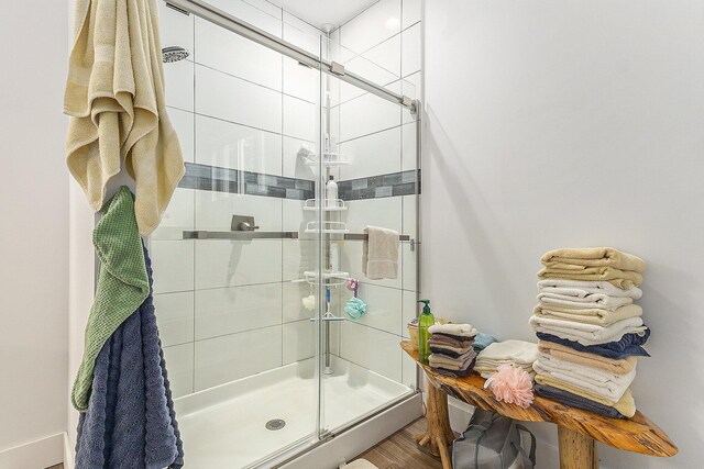 bathroom featuring a shower with shower door and hardwood / wood-style floors