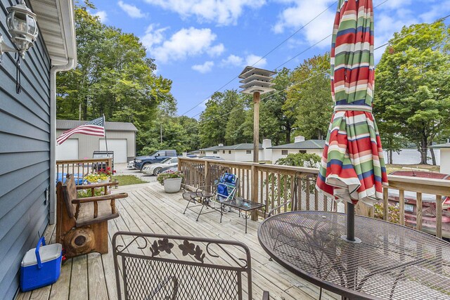 wooden deck with a garage and an outdoor structure