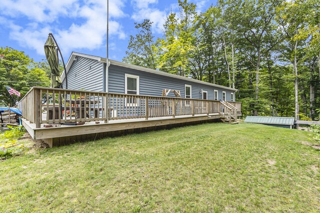 back of house with a deck and a yard