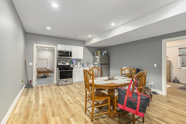 dining room featuring sink and light hardwood / wood-style flooring