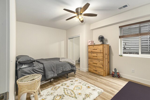 bedroom with light hardwood / wood-style flooring, a closet, and ceiling fan