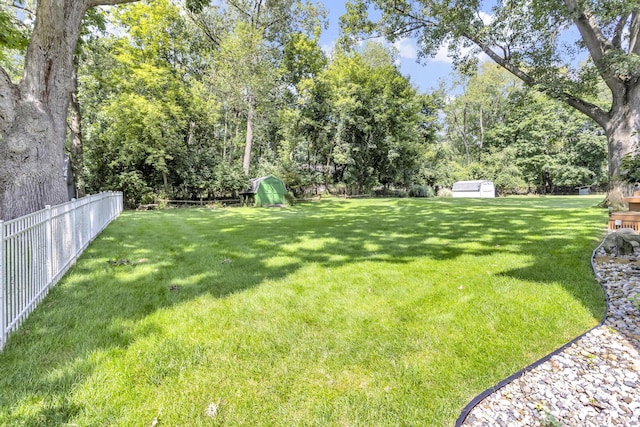 view of yard with a fenced backyard and a storage shed