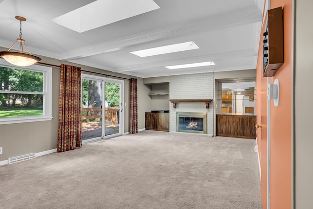 unfurnished living room featuring a skylight, visible vents, beamed ceiling, carpet floors, and a brick fireplace