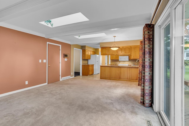 kitchen with white appliances, a skylight, visible vents, open floor plan, and decorative light fixtures