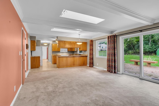 kitchen with light colored carpet, a skylight, light countertops, decorative light fixtures, and crown molding