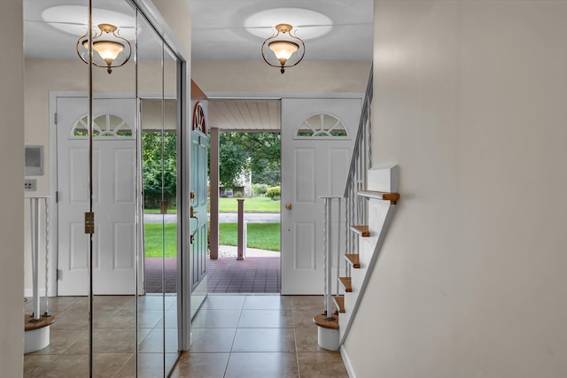 foyer with light tile patterned floors and stairway