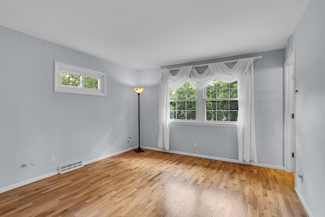 empty room with baseboards, visible vents, and light wood-style floors