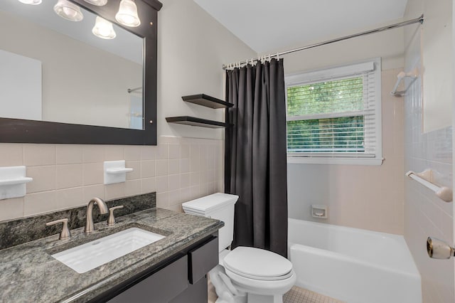 bathroom with vanity, tile walls, toilet, and shower / bath combo with shower curtain