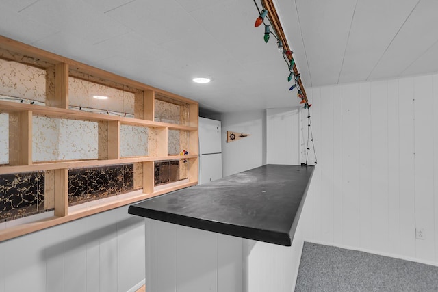 interior space with dark countertops, freestanding refrigerator, carpet, and open shelves