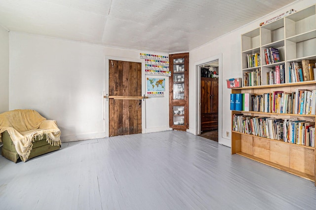 living area with baseboards and wood finished floors