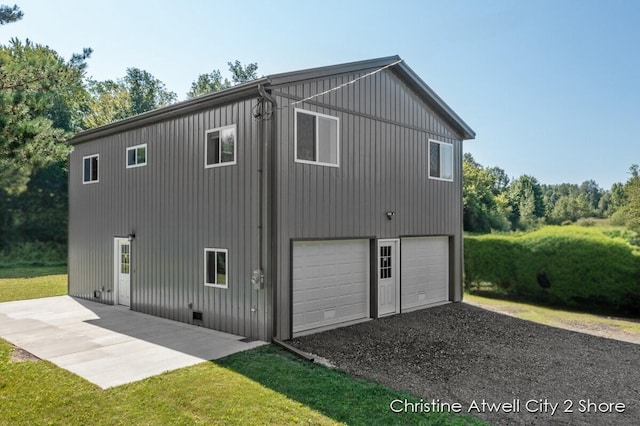 view of side of property with a garage and a lawn