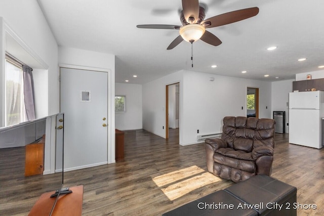 living room with ceiling fan, dark wood-type flooring, and baseboard heating