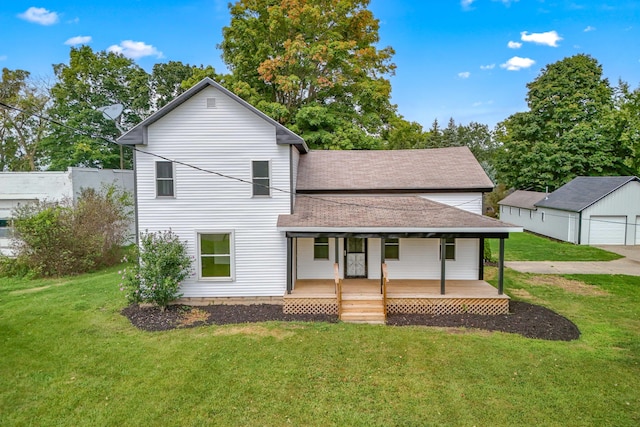 view of front of home featuring a porch, a garage, an outbuilding, and a front lawn