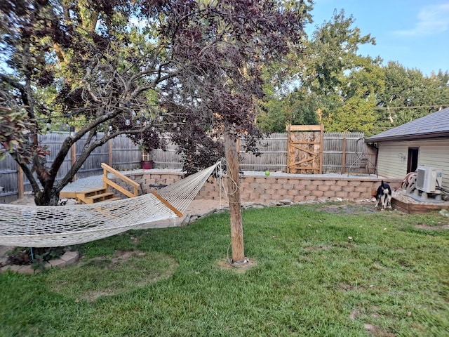 view of yard with a fenced backyard and ac unit