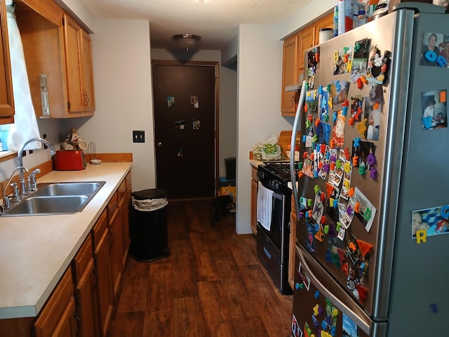 kitchen featuring stainless steel refrigerator, sink, black electric range oven, dark hardwood / wood-style floors, and a textured ceiling